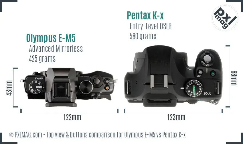 Olympus E-M5 vs Pentax K-x top view buttons comparison